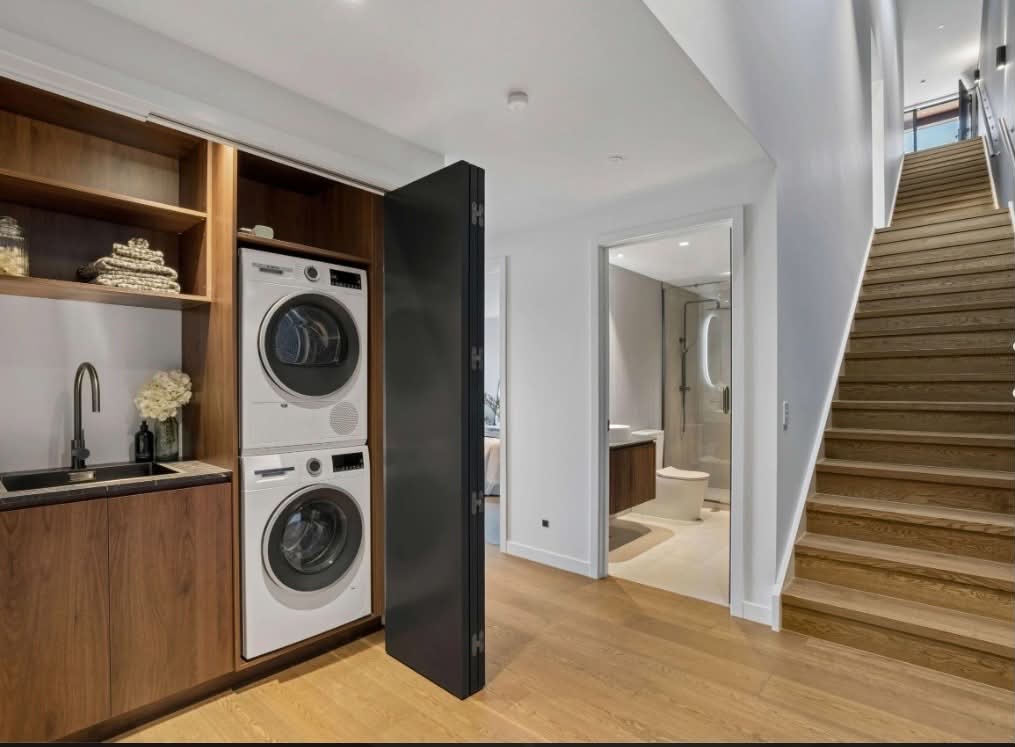 Timber-lined utility with walnut cabinetry and crisp white walls