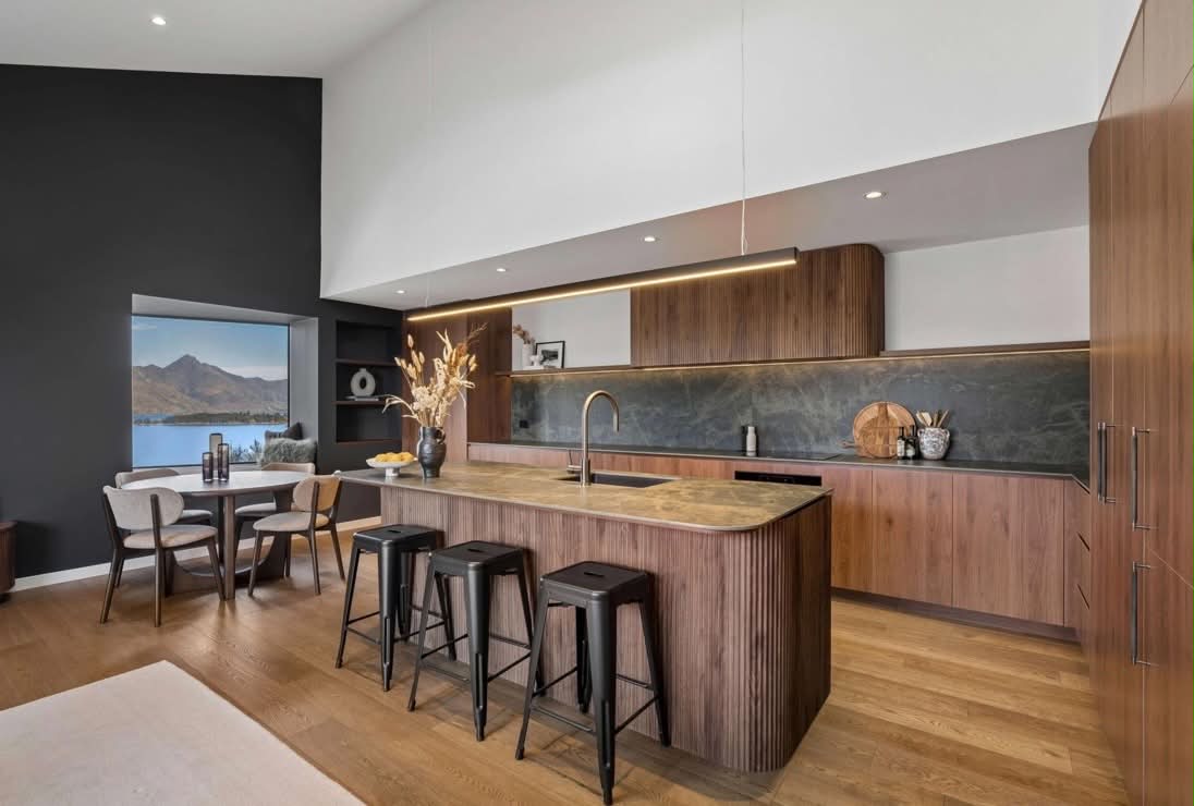 Timber kitchen and dining with charcoal feature wall and lake view