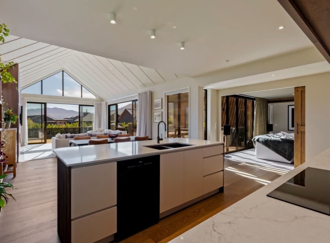 Modern kitchen and living area with vaulted ceiling and mountain outlook