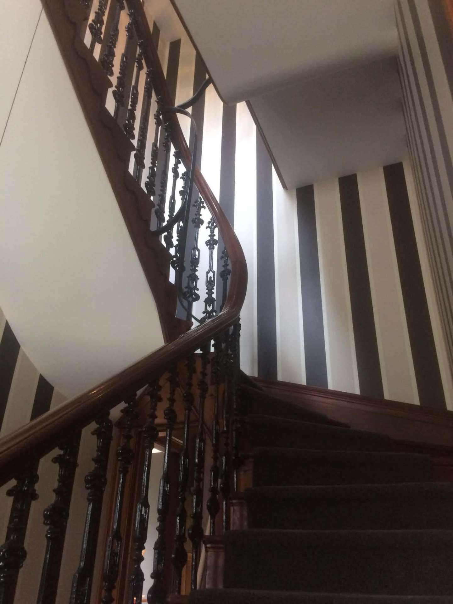 Heritage staircase with bold black and white striped feature wall
