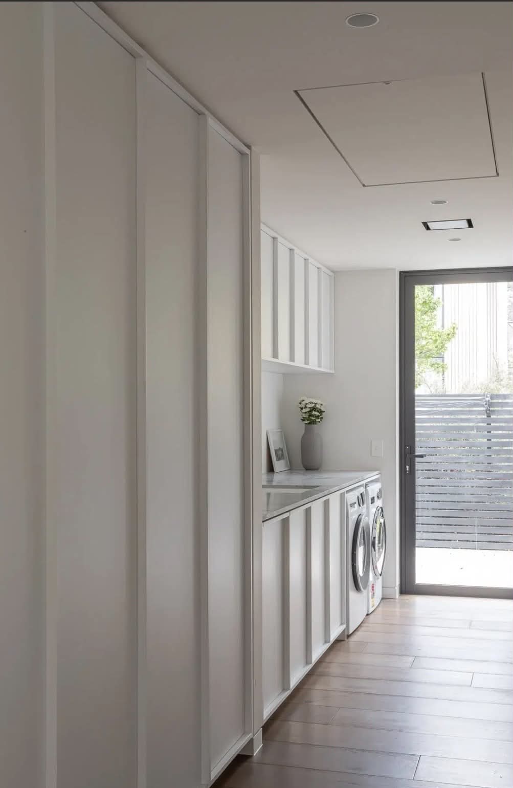 Bright white laundry with tall built-in cabinetry