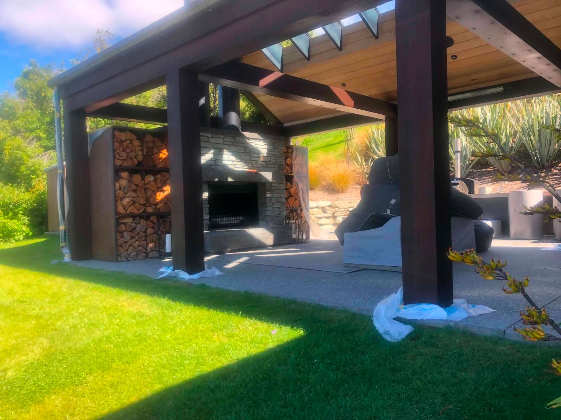 Outdoor entertaining pavilion with dark stained timber posts and beams